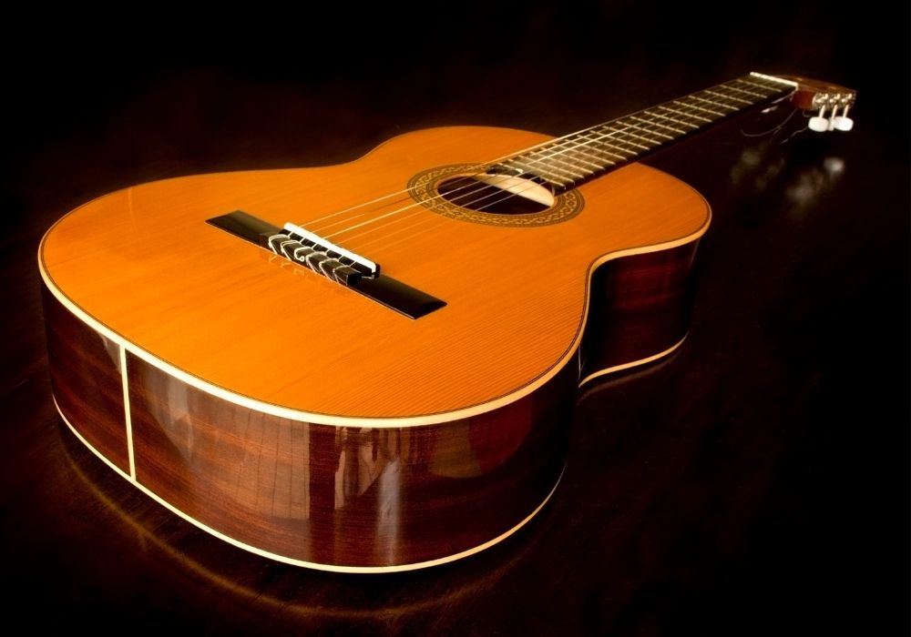 A classical guitar on a black background