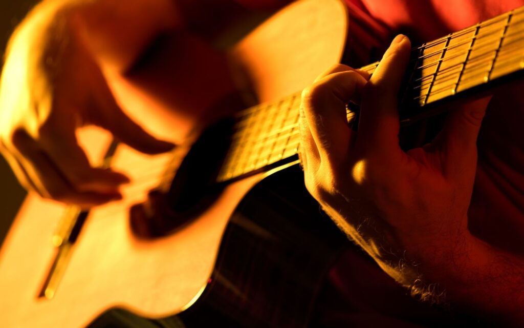 A guitarist strumming a classical guitar