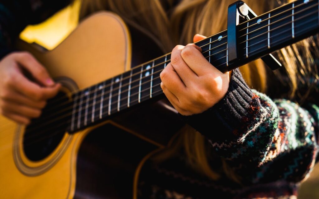 A guitarist strumming a guitar for travel