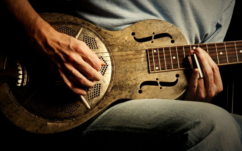 A guitarist strumming a resonator guitar