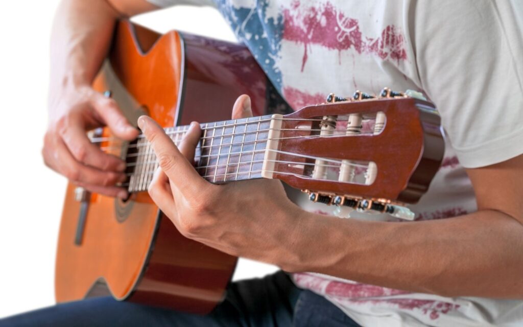 A guitarist strumming one of the best acoustic guitars for fingerstyle