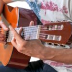 A guitarist strumming one of the best acoustic guitars for fingerstyle