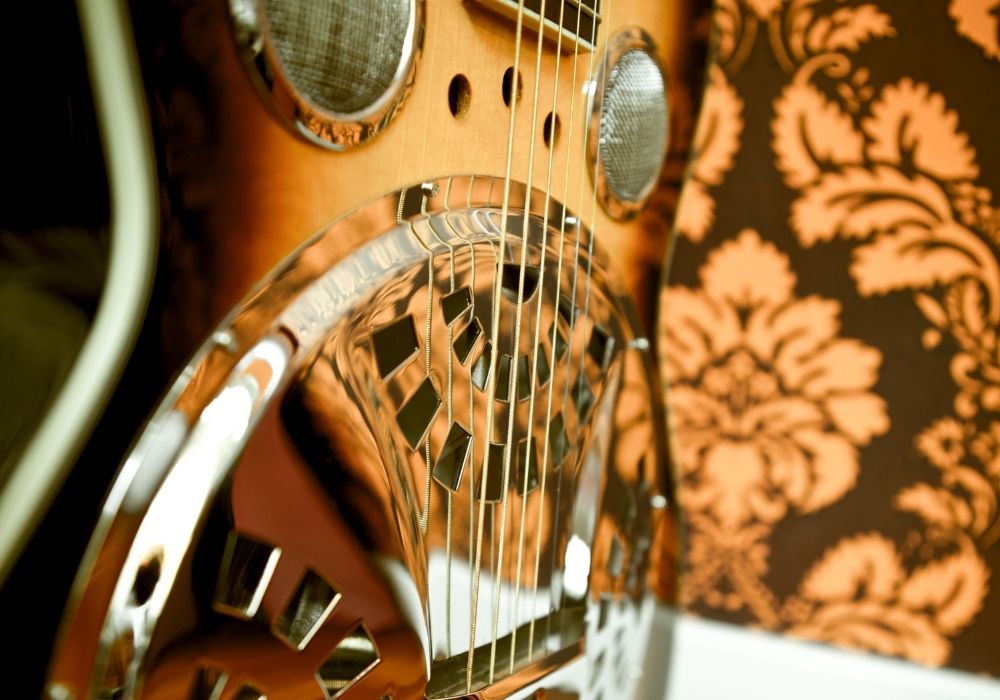 An up-close of a resonator guitar on the wall