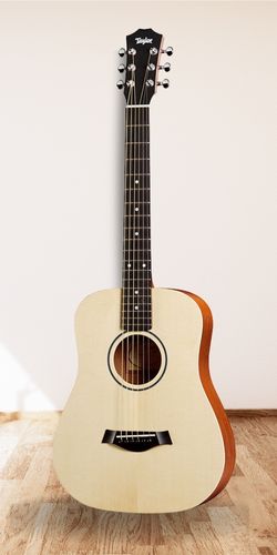 Baby Taylor Acoustic Guitar in studio on wood floor with white background