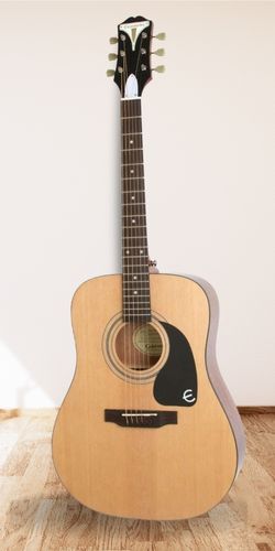 Epiphone Pro-1 Acoustic Guitar on wooden floor white wall background