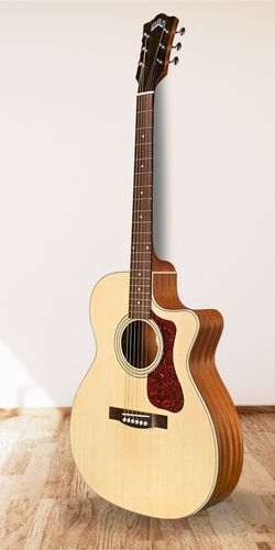 Guild OM-240 CE Acoustic Guitar on wood floor white wall background