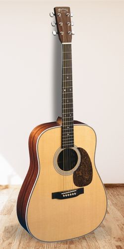 Martin HD-28 Acoustic Guitar on the floor with a white wall as the background