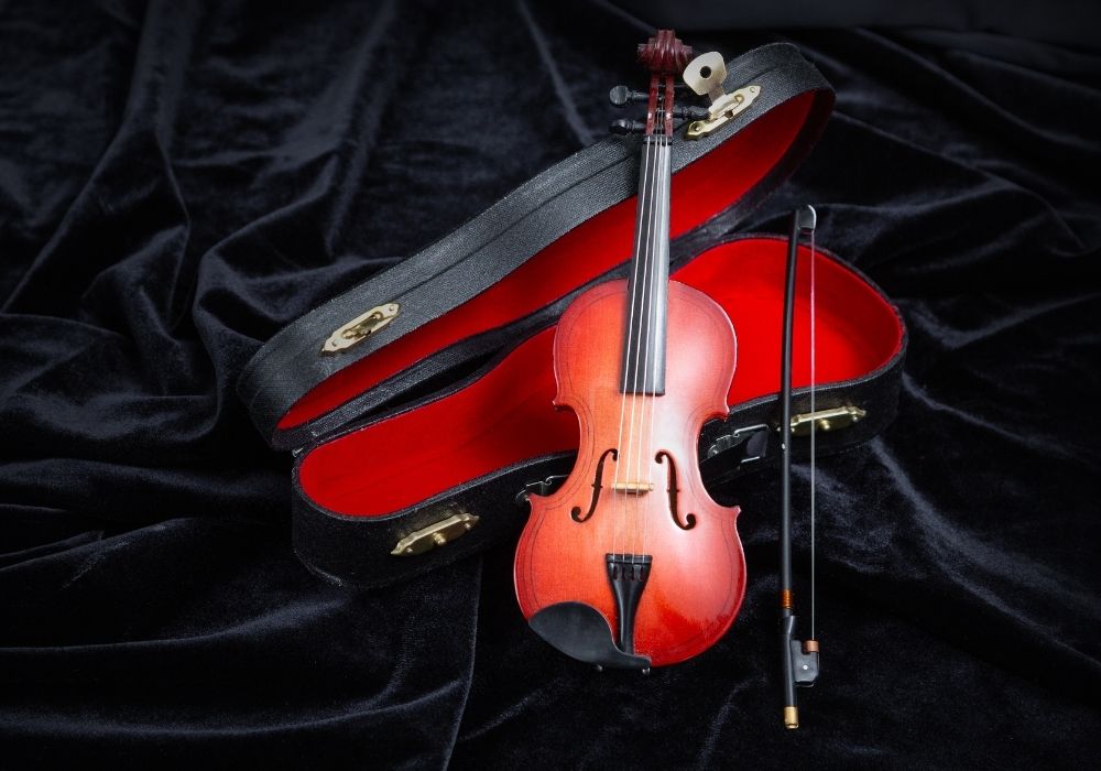 Violin with a case on dark velvet
