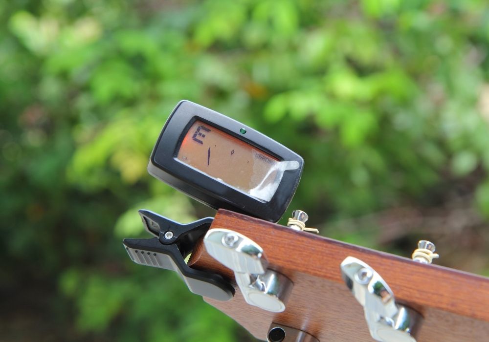 A close-up acoustic guitar tuner