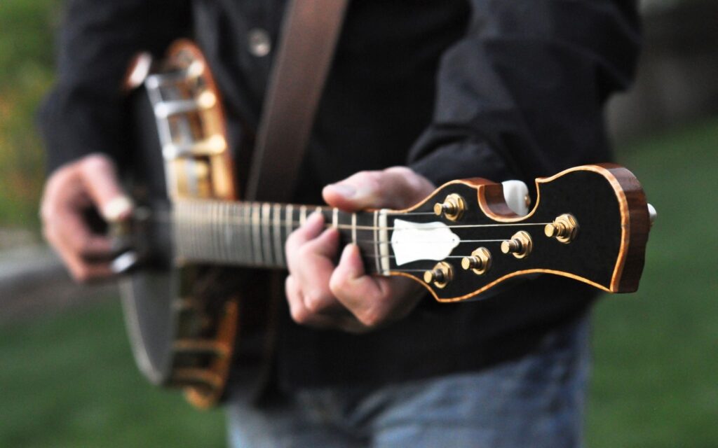 A close up photo of a musician playing a professional banjo