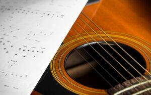 A music sheet and an acoustic guitar