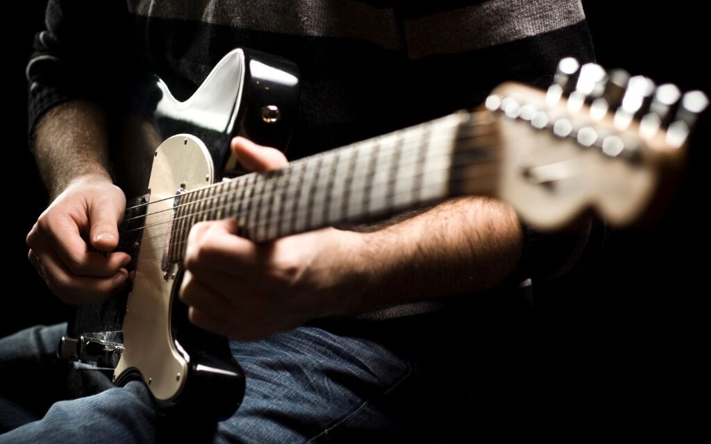 A musician strumming his electric guitar