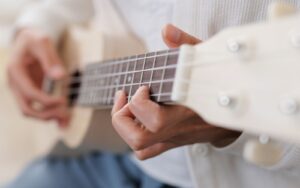 a musician strumming a ukulele instrument
