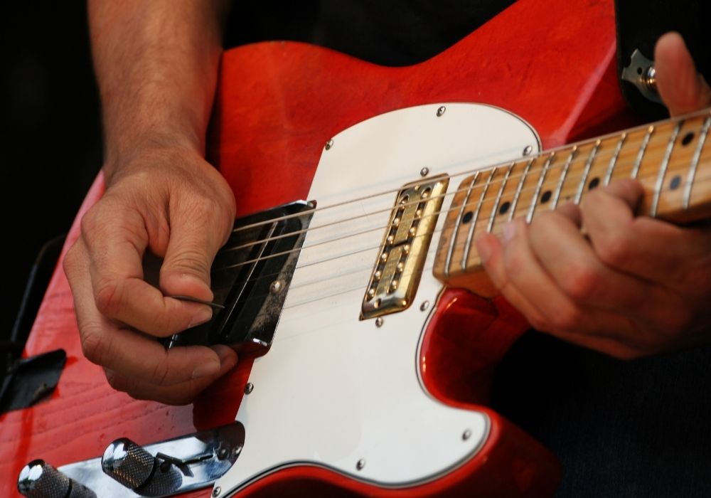 A guitarist playing an Electric Guitar using a guitar pick