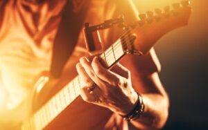 Close up detail of man hand playing an electric guitar song