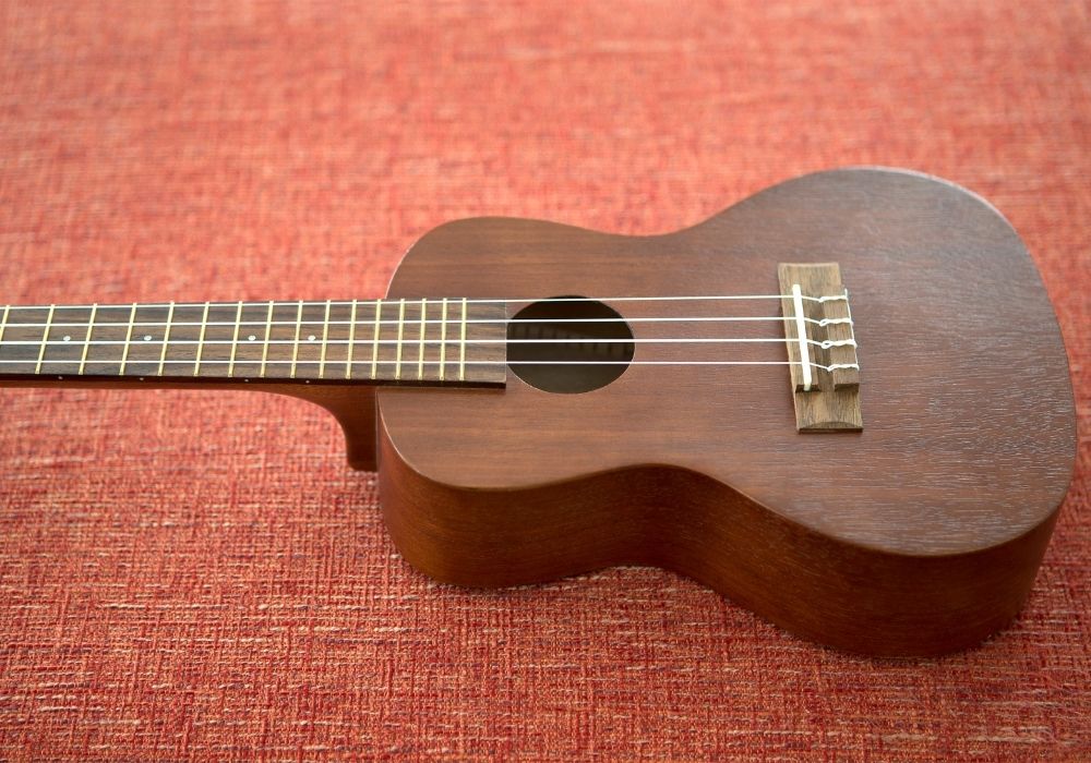 a concert ukulele on a red background