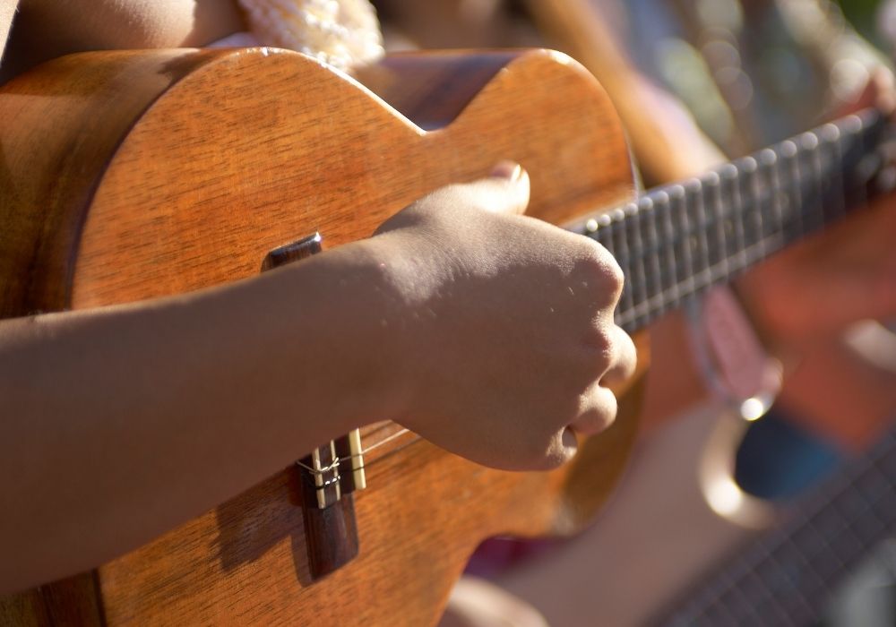 a kid is plucking one of the best ukulele for kids
