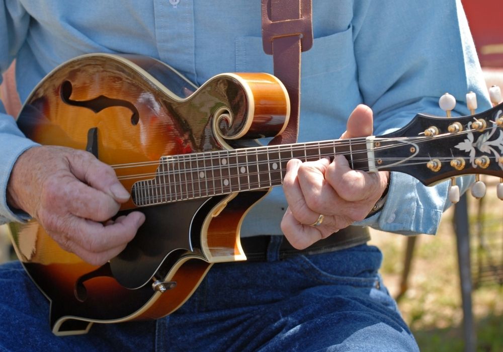a man playing an A-Style mandolin