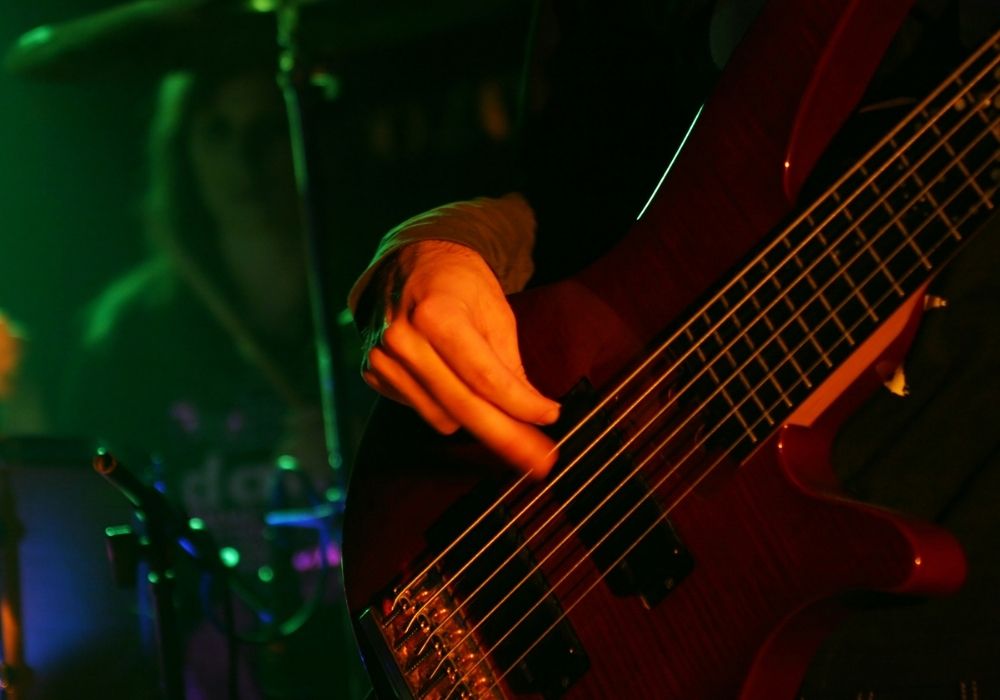 bass guitarist on stage using a one of the best bass guitar pick