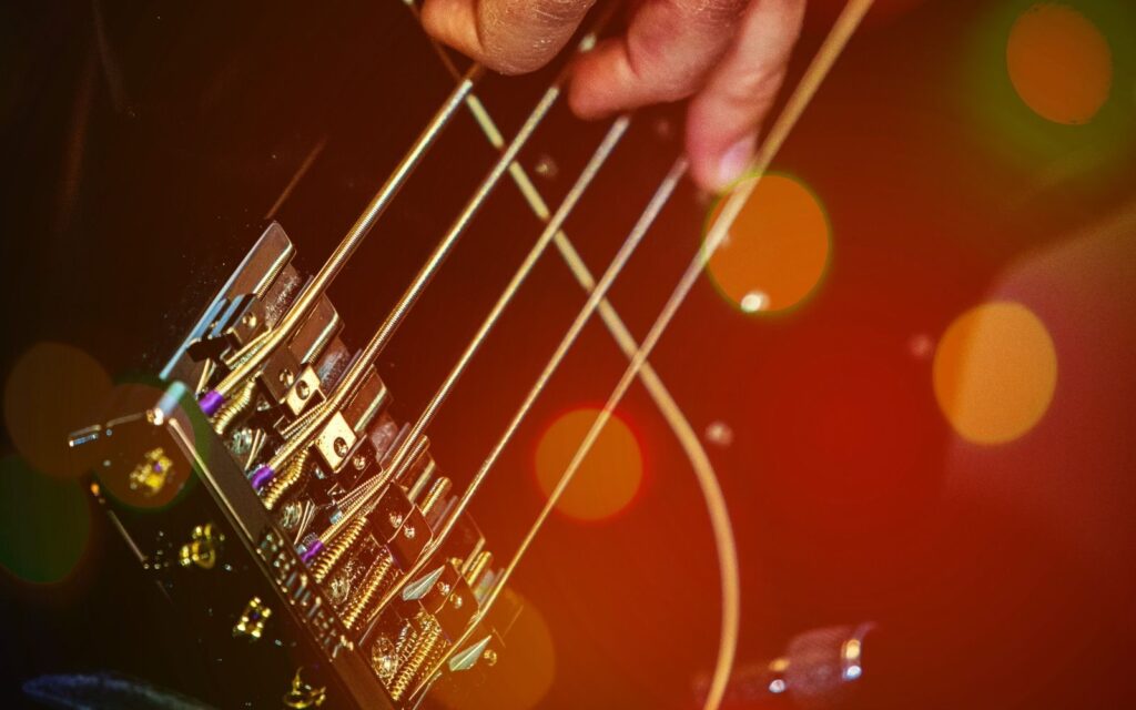 bass guitar musician playing close up black