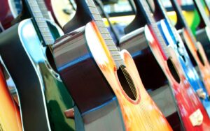An array of acoustic guitars with different colors like yellow, green, red and blue.