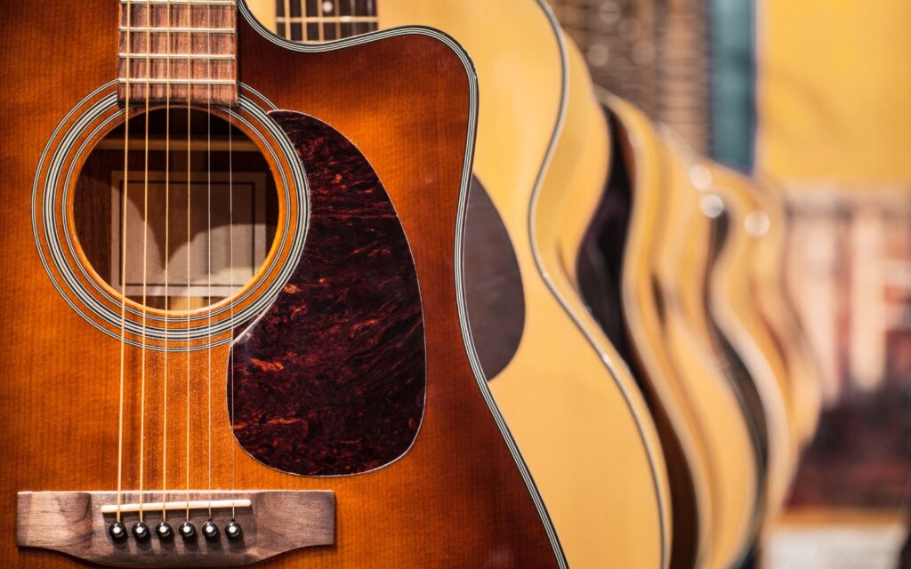 An array of acoustic guitars hanging on the wall.