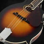 A Gretsch G9350 mandolin on a black background.
