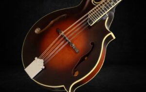 A close look at the J Bovier F5-T mandolin on a black background.